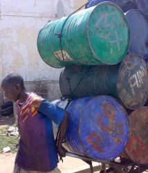 Youth pushing oil drums in Kano