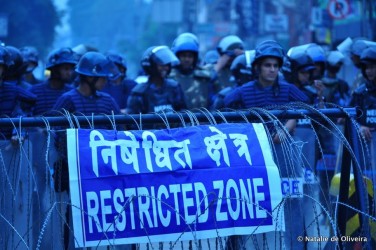 Photo: A police blockade around the demonstrations. A protestor among the crowds in Kathmandu. Credit: Natalie de Oliveira