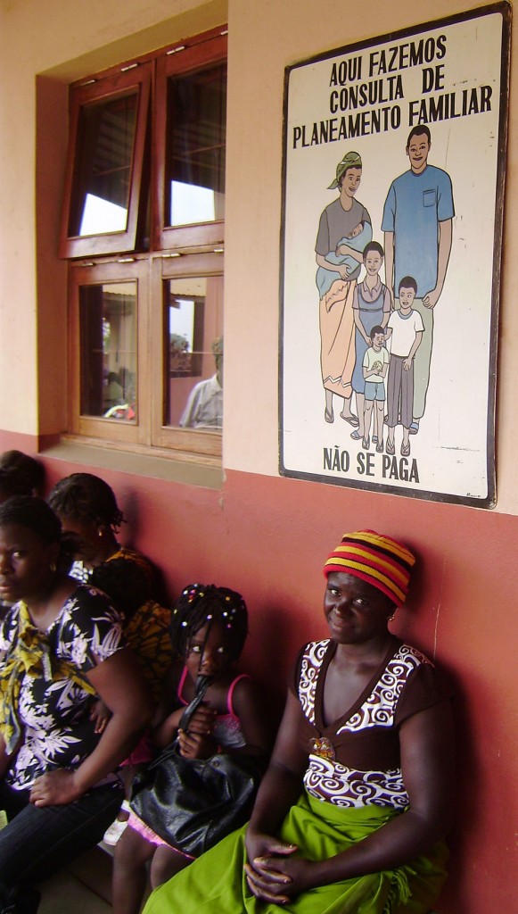 Photo of women sitting waiting under a poster