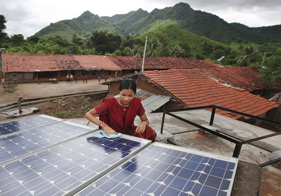 Photo of a woman wiping solar panels