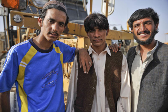 Photo of three men in front of a road digger