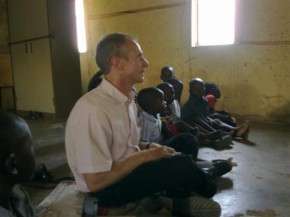 Ian sitting on the floor in a classrom