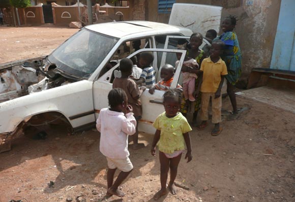 Children play in an abandoned car