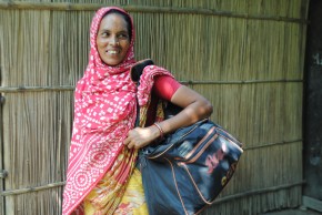 A woman carries a bag of goods to sell