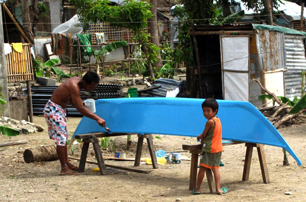 A man repainting his boat on Canas island. Picture: Henry Donati/DFID