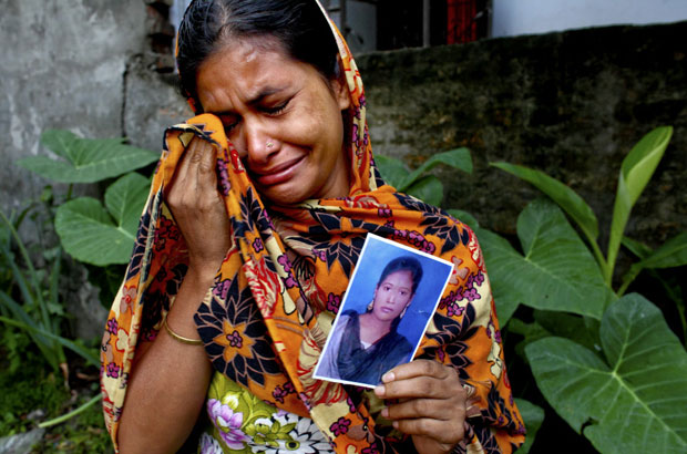 The mother of 18 year old Aleyais cries and holds a picture of her daughter who is believed to be among the victims of the collapse of the Rana Plaza complex in Savar on the outskirts of Dhaka.