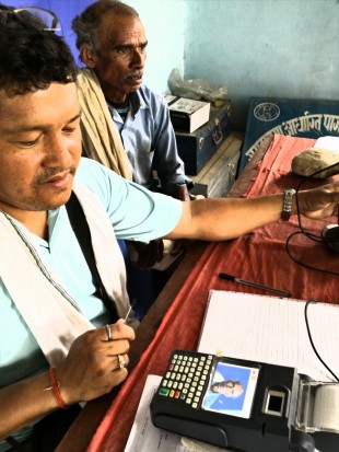 An agent opens an account with a point of sales (POS) machine. The POS machine has a camera that can take a picture of the account holder, which is compulsory as per the Central Bank's regulations. . Picture: Prasanna Bahadur/DFID