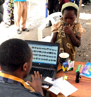 A young recipient has her ID checked on the database. Picture: Chris Pycroft/DFID DRC