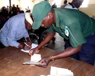 Pay day: Securico staff checking ID's and administering payments to beneficiaries. Picture: Samantha Coope/DFID