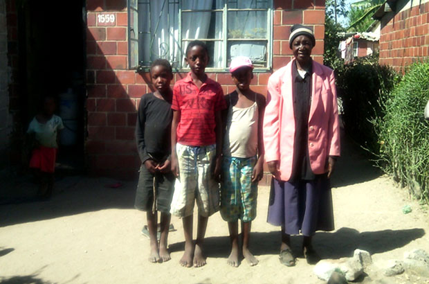 Nyasha with 3 of her 5 grandchildren outside their home. Picture: Harriet Macdonald – Walker/DFID