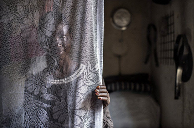 A young Somali woman hides herself behind a curtain. Picture: Sven Torfinn/Panos