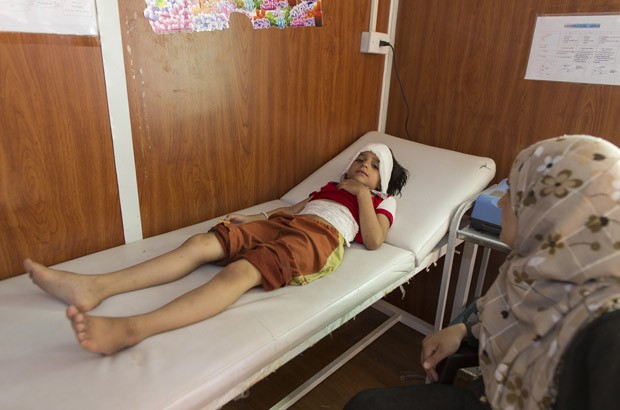 A Syrian mother waits by her daughter’s side as she gets medical attention in Zaatari refugee camp in Jordan. Picture: David Brunetti/ Doctors of the World