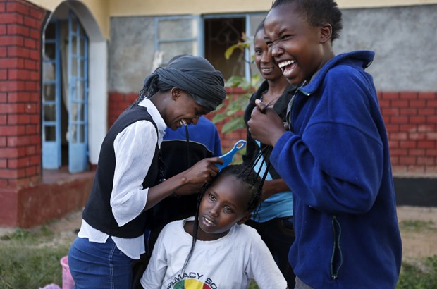 Eunice, 13, helps braid the hair of another resident. In Kenya, girls are most vulnerable to FGM and forced marriage during the school holiday breaks. Picture: Newsha Tavakolian for TooYoungToWed/The Girl Generation.